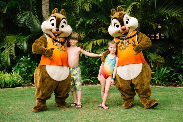 Chip and Dale on the lawn of Disney Aulani with two kids in swimsuits
