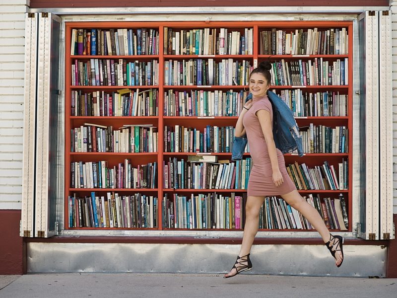 Girl walking in front of outdoor bookshelf downtown salt lake city
