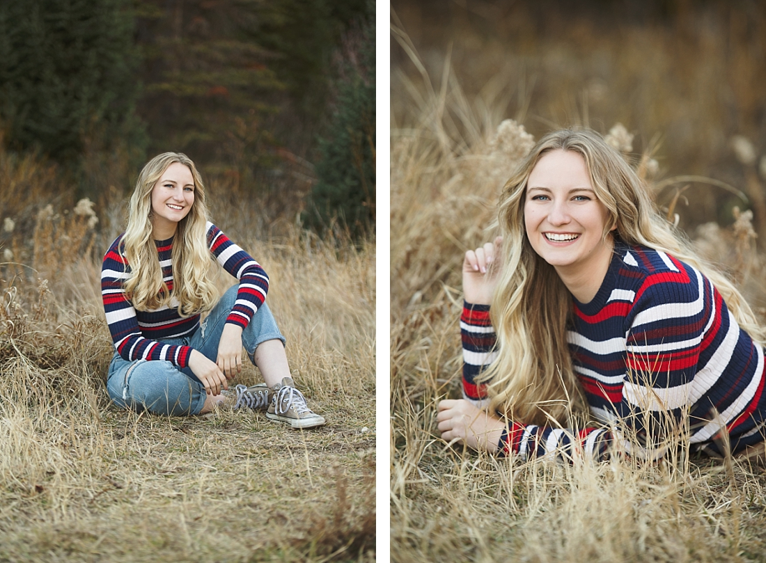 Utah High School senior girl sitting in autumn grass wearing a striped sweater and jeans