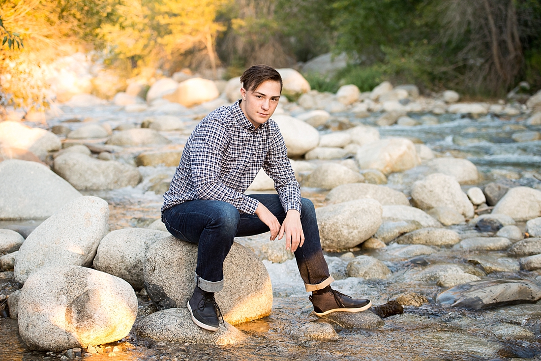 Amanda Nelson Photography senior portraits boy sitting by river on a rock.