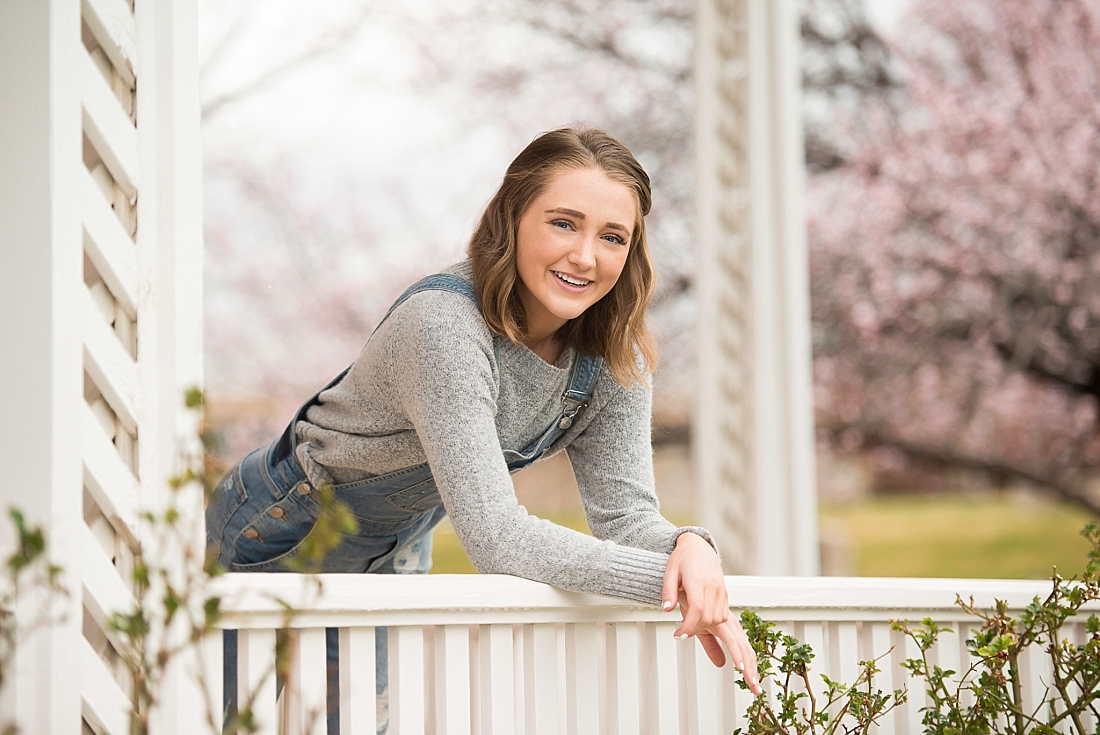 Amanda Nelson Photography senior portraits with white porch and pink blossoms