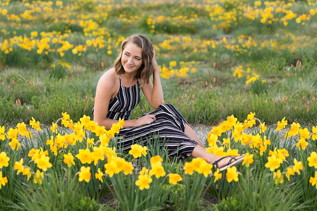 Skyline High School senior wearing a black and white striped jumper sitting in a field of daffodils