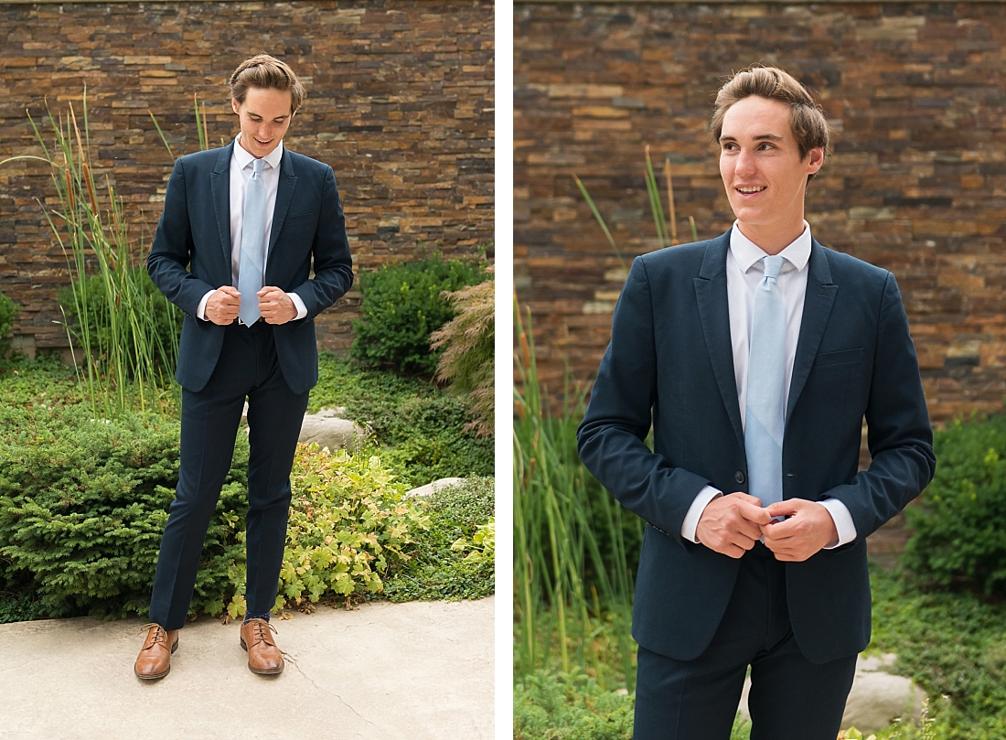 The Waterford School senior portraits of boy in a suit with light blue tie against a rock wall