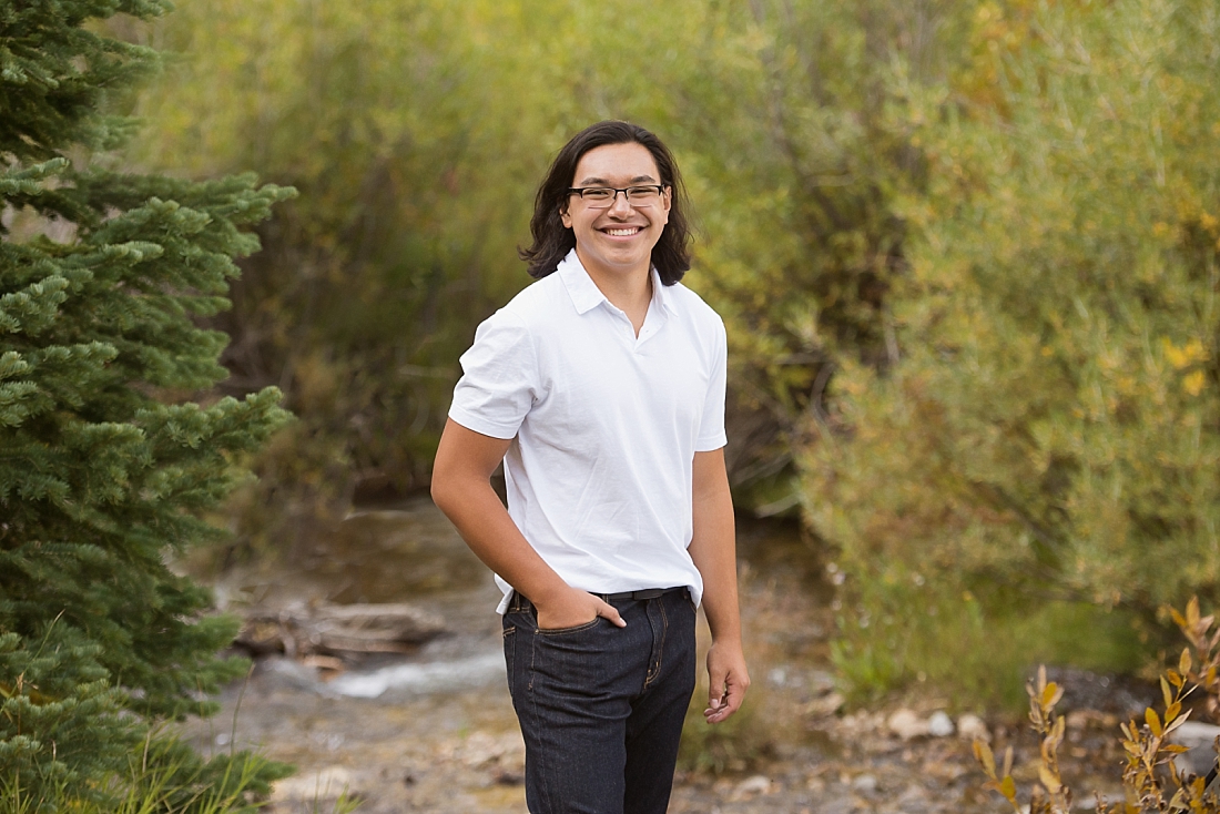 Senior portraits by a stream in the mountains.
