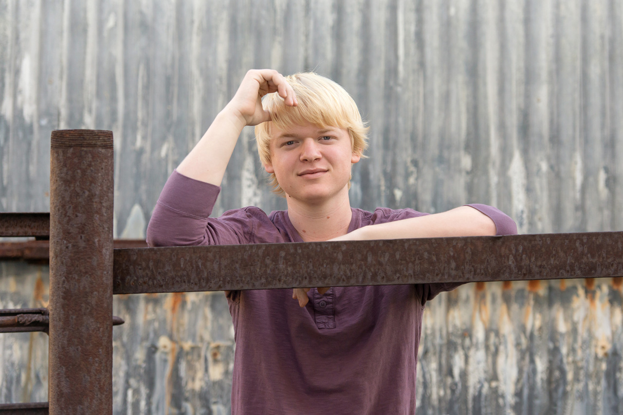 Waterford School senior portraits at McPolin Farm. Standing in front of a corrugated metal barn.