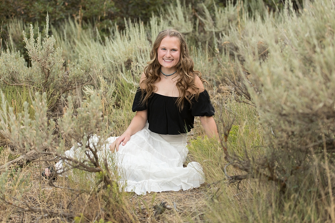 Amanda Nelson Photography, girl sitting in desert sage wearing white skirt and black shirt