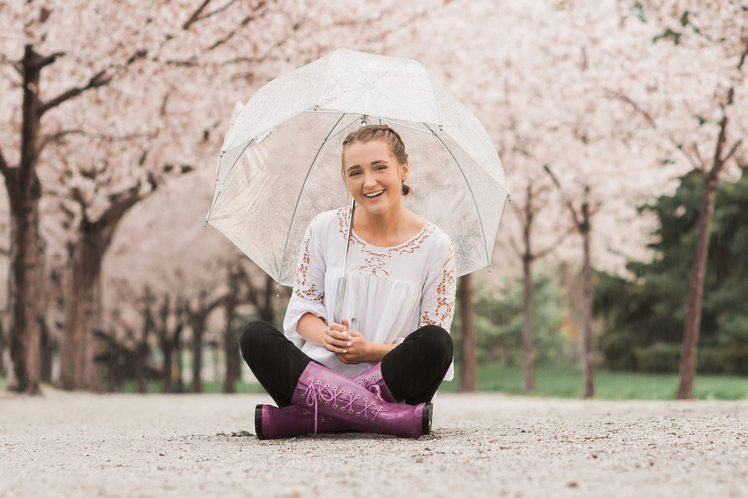 Senior portraits in the blossoms with umbrella