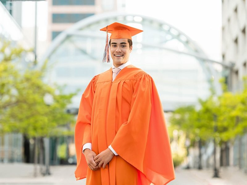 boy in orange graduation cap and gown, brighton high school, utah senior portraits