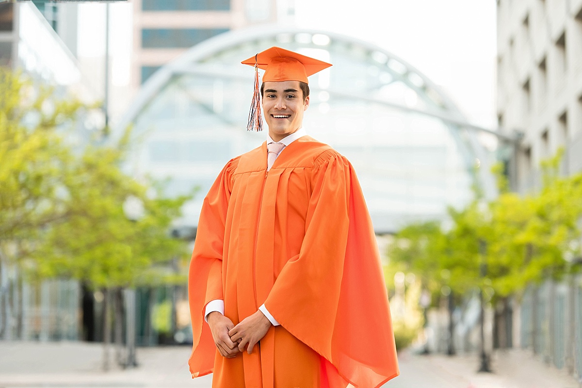 boy in orange graduation cap and gown, brighton high school, utah senior portraits