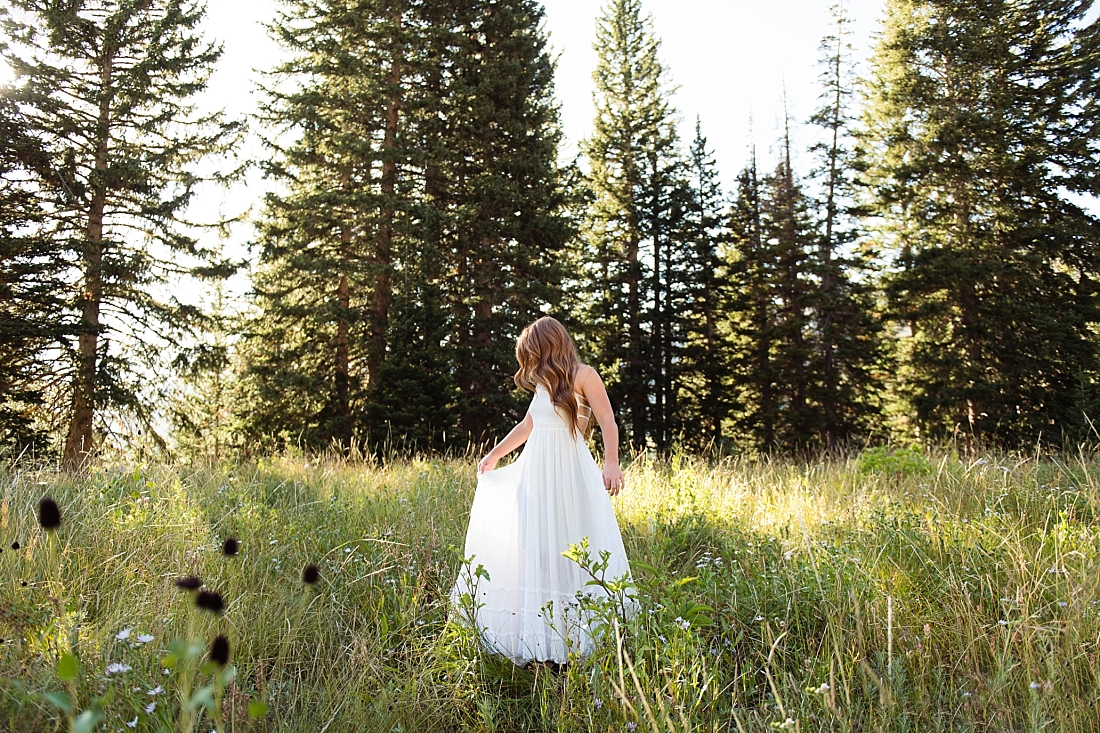 Farmington Senior pictures of a girl in long white dress swaying in the trees